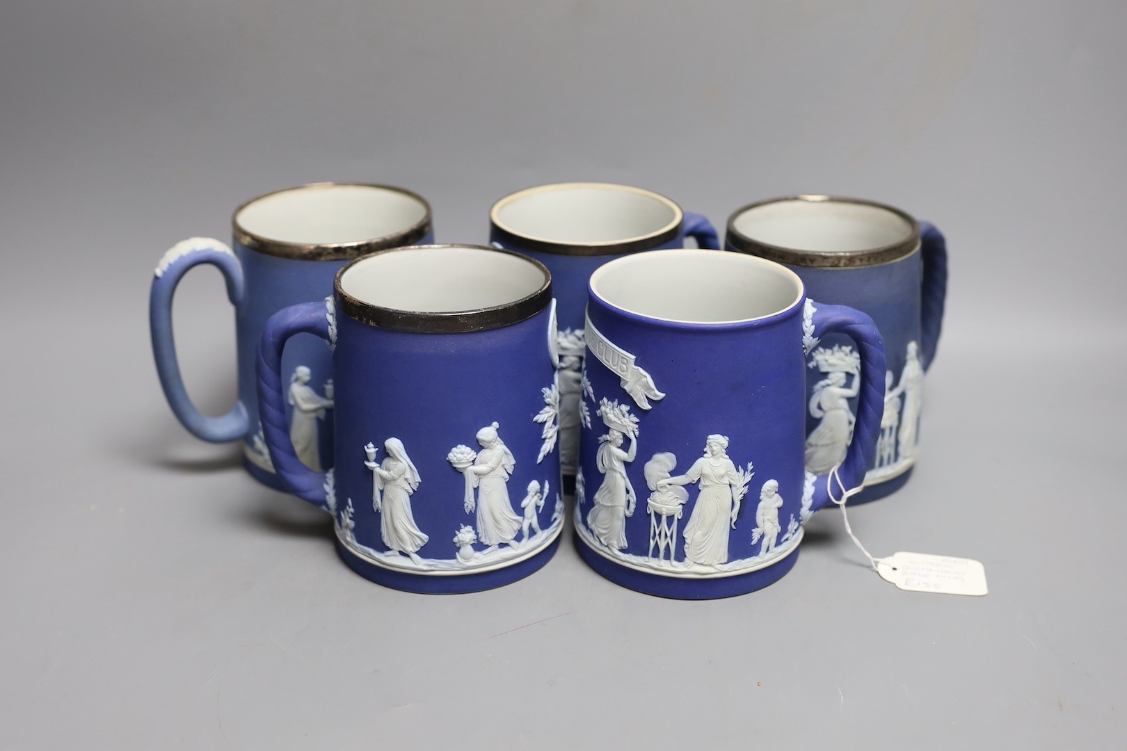 Five Wedgwood for Elkington & Co. blue jasper rifle or shooting club trophy mugs, 12.5cm high some with silver mounted rims, including Richmond rifle club, London Scottish etc.